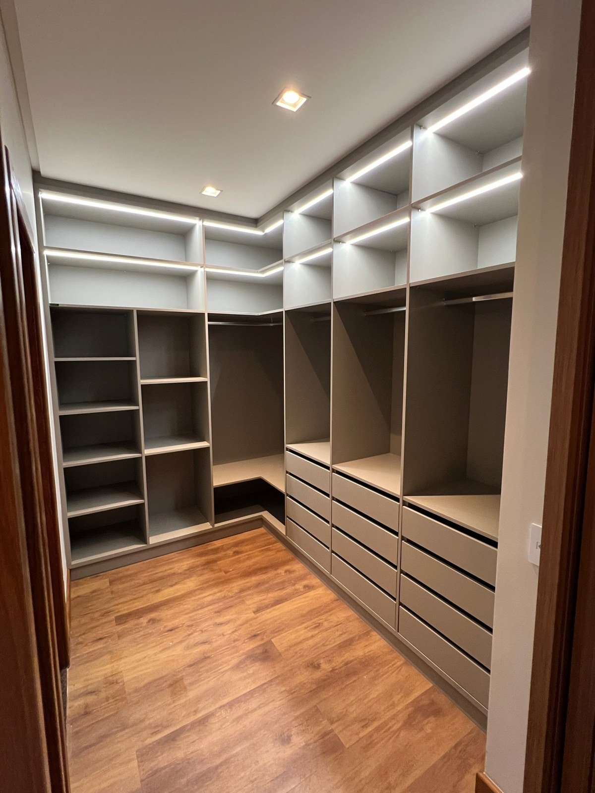 Closet planejado com prateleiras, gavetas e iluminação em LED